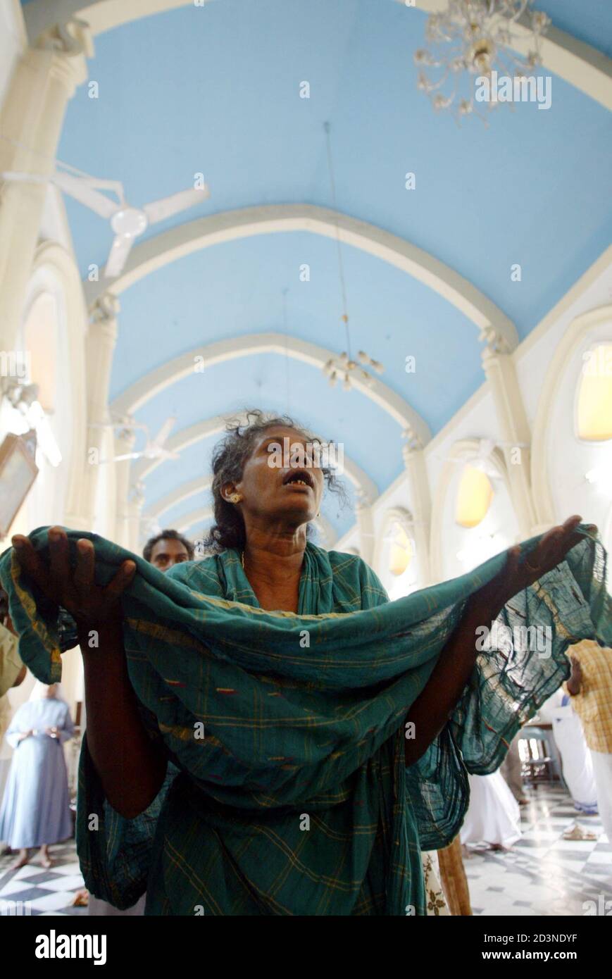 Un sobreviviente del tsunami ofrece una oración en una iglesia en Velankanni, a 365 km al sur de la ciudad India de Madras el 9 de enero de 2005. El tsunami de diciembre de 26, desencadenado por un terremoto submarino en Indonesia, ha matado a unas 150,000 personas en el sur y sureste de Asia, más de 15,000 en la India solamente. REUTERS/Amit Dave AD/THI Foto de stock