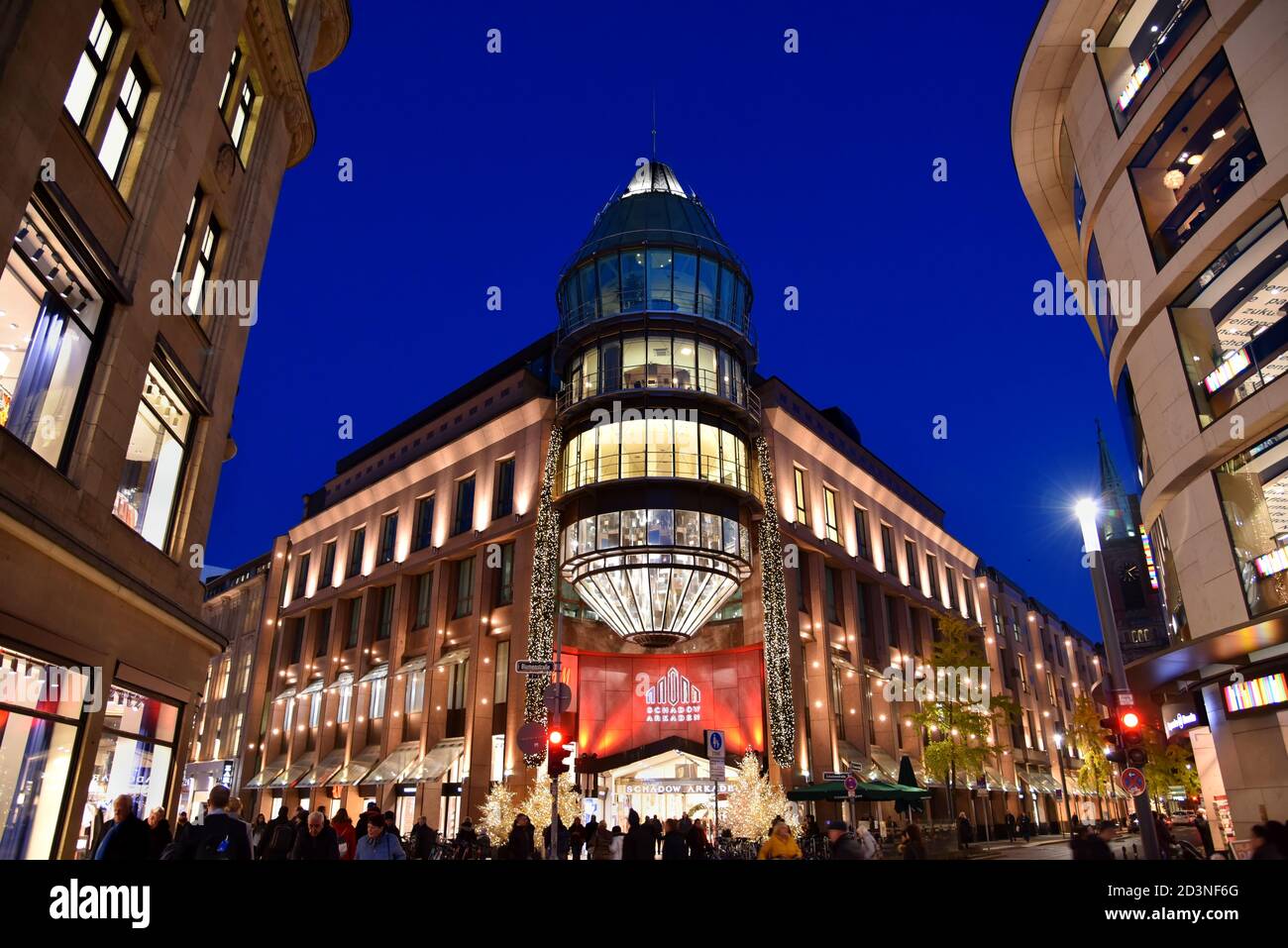 Fachada moderna del centro comercial 'Schadow-Arkaden' en el centro de Düsseldorf con iluminación navideña. Foto de stock