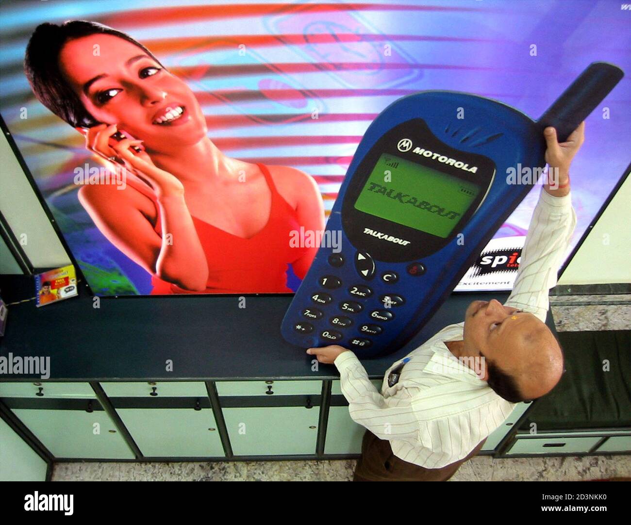 Un trabajador indio adjunta un modelo de teléfono móvil a una cartelera  publicitaria en la ciudad India oriental de Calcuta el 19 de diciembre de  2001. La Asociación de operadores celulares de