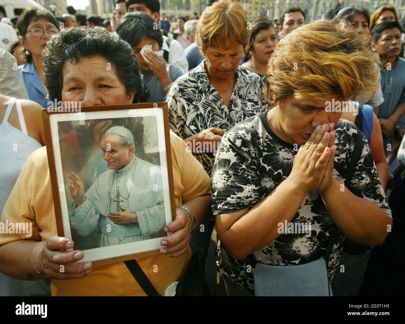 Los peruanos oran y lloran mientras aprenden la noticia de la muerte del  Papa Juan Pablo II fuera de la catedral de Lima, 2 de abril de 2005. El  Papa Juan Pablo