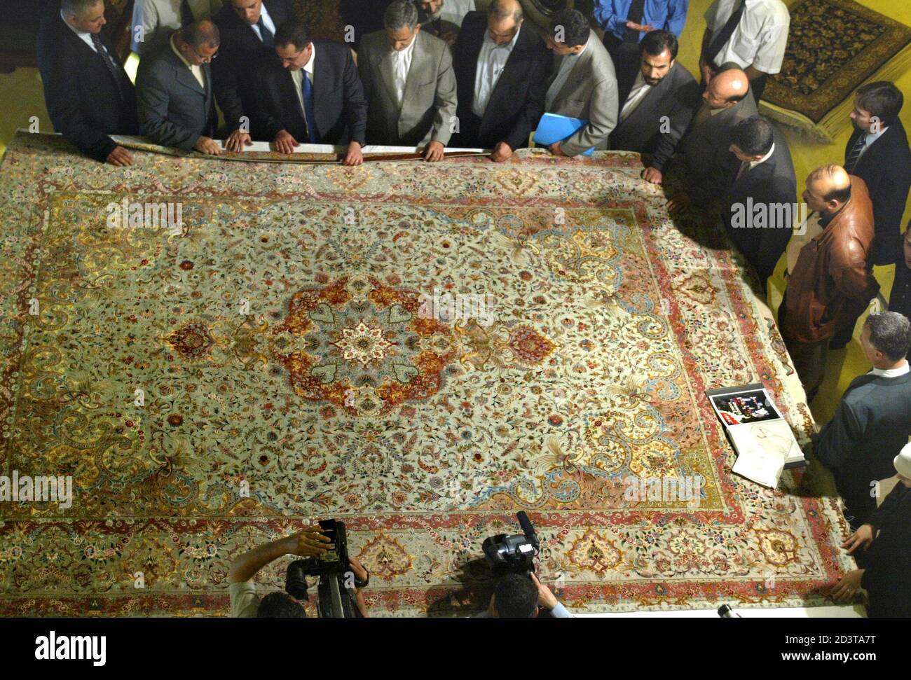 Funcionarios jordanos e iraníes miran una colorida alfombra de seda hecha a  mano de Tabriz en la ceremonia de apertura de una exposición de alfombras  hechas a mano en Ammán el 26