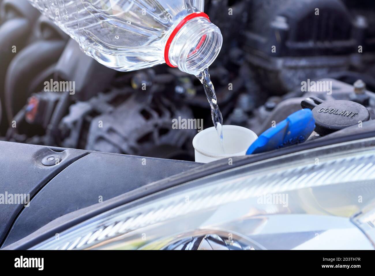Verter agua destilada (alternativa ecológica al líquido de lavado) en el  tanque de lavado en el coche, detalle sobre una botella de plástico  transparente Fotografía de stock - Alamy