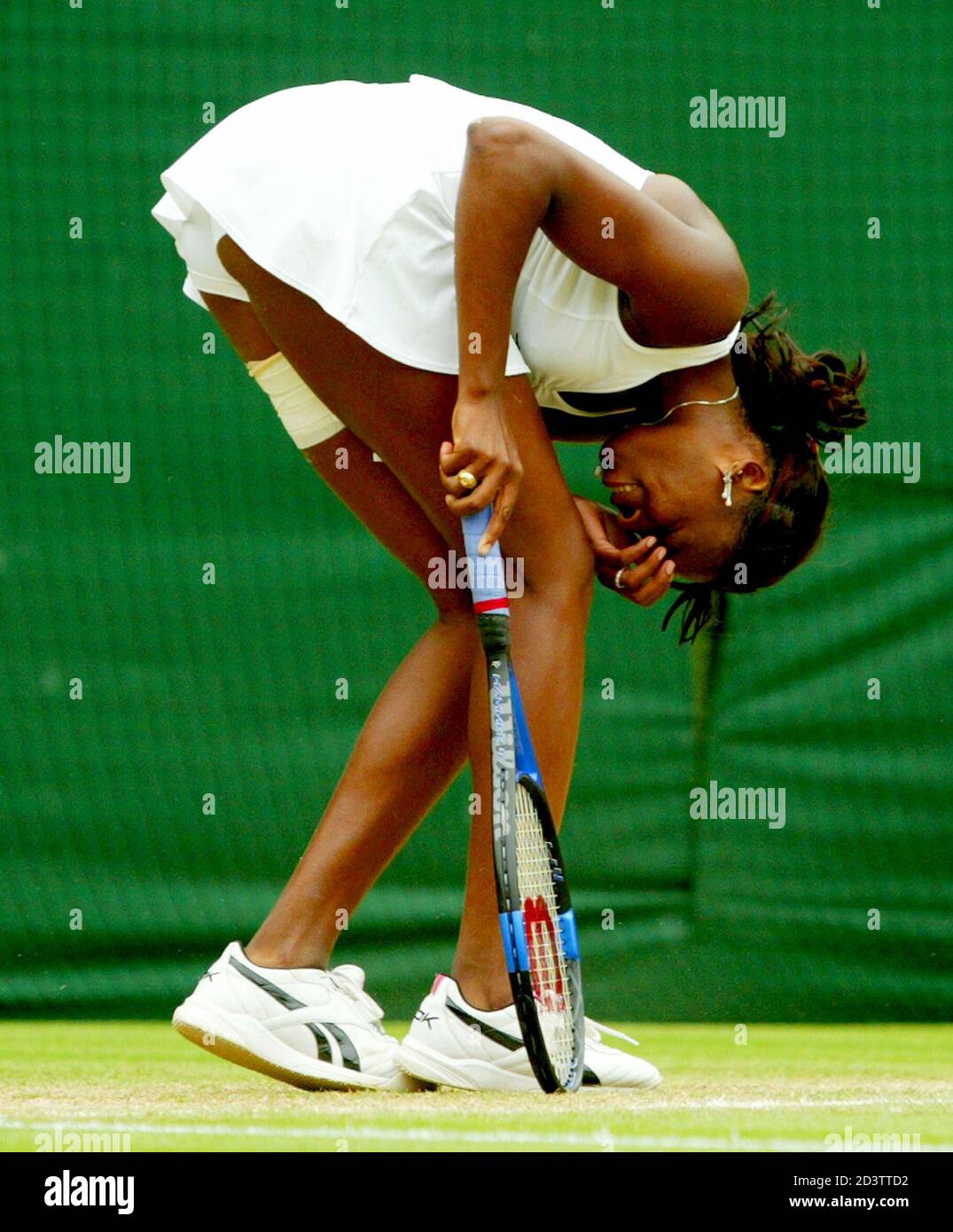 Venus Williams de los EE.UU. Se duplica durante el partido final de sus mujeres individuales contra su hermana Serena en la cancha central en el Campeonato de de Wimbledon Londres,