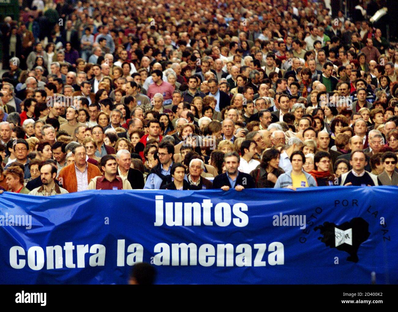 MILES DE PARTIDARIOS DEL GRUPO PACIFISTA VASCO 'GESTO POR LA PAZ' (GESTO POR LA PAZ) MARCHAN POR EL CENTRO DE BILBAO. Miles de partidarios del grupo de paz basado en el país Vasco "Gesto por la Paz" (gesto por la Paz) llevan una pancarta que dice "juntos contra la amenaza" durante una marcha por el centro de Bilbao el 2 de febrero de 2002, Celebrar el decimoquinto aniversario de la Organización y comemorar la asación del líder indio Mahatma Gandhi. La organización separatista vasca ETA, que ha sido llamada un "grupo terrorista" por la UE, ha matado a más de 800 personas desde entonces Foto de stock