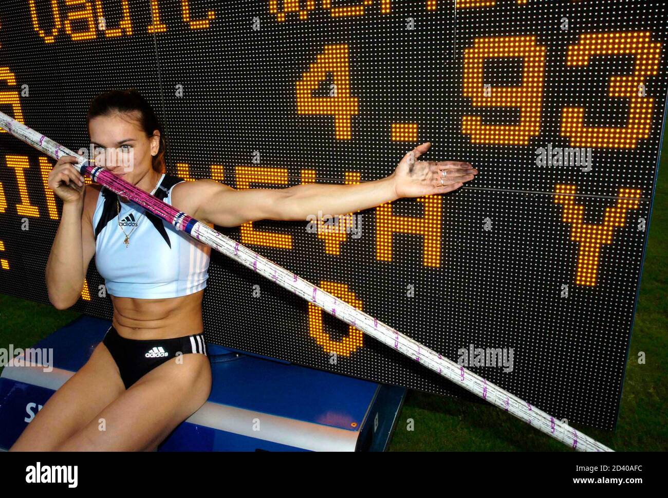 Russian pole vaulter Yelena Isinbayeva poses in front of a scoreboard