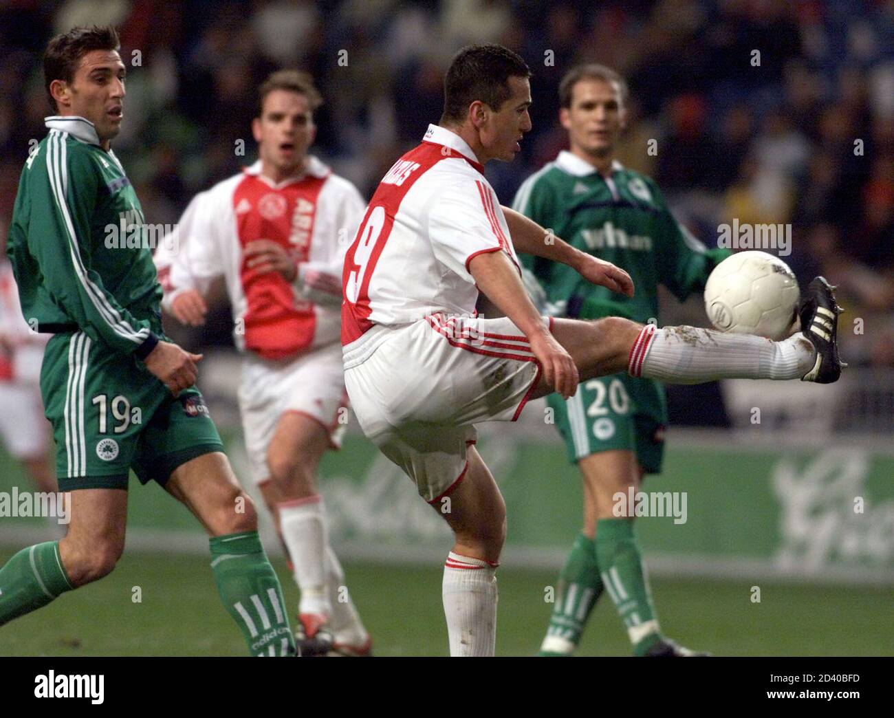El jugador griego Ajax Nikos Machlas controla el balón frente al gol,  mientras que los jugadores de Panathinaikos Blendar Kola (L) y Agelos  Basinas (R) observan durante un partido amistoso para celebrar