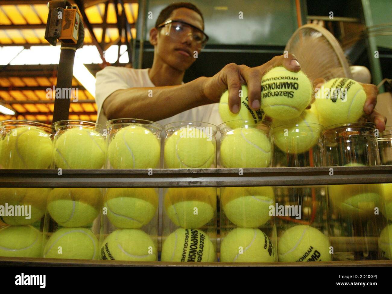 UN TRABAJADOR FILIPINO COLOCA PELOTAS DE TENIS EN CONTENEDORES DE PLÁSTICO  EN UN CINTURÓN TRANSPORTADOR EN LA FÁBRICA DE DUNLOP SLAZENGER EN BATAAN  Fotografía de stock - Alamy