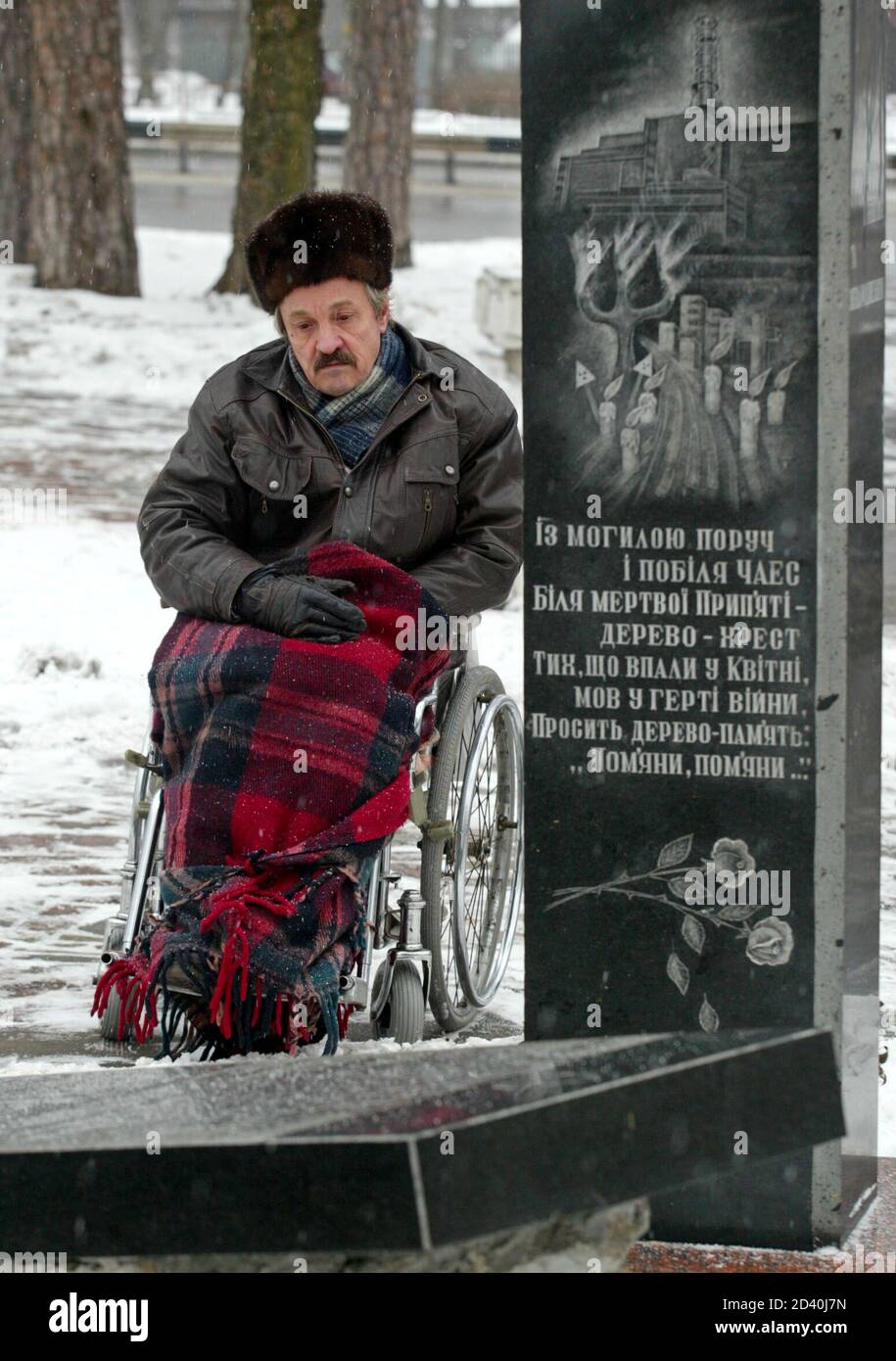 Un trabajador ucraniano, que ayudó a limpiar las consecuencias del desastre  nuclear de Chernobyl, se sienta en una silla de ruedas cerca de un  monumento a las víctimas de Chernobyl durante una