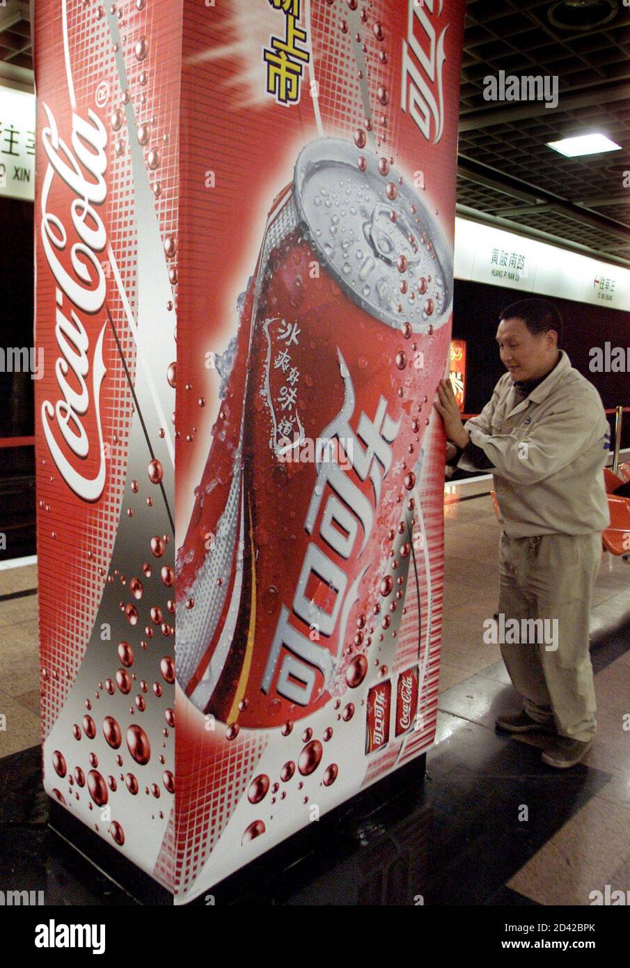 Un trabajador pone un anuncio para el fabricante estadounidense de bebidas  gaseosas Coca-Cola con su primer logotipo de guión chino en una estación de  metro en Shanghai, la capital de negocios de
