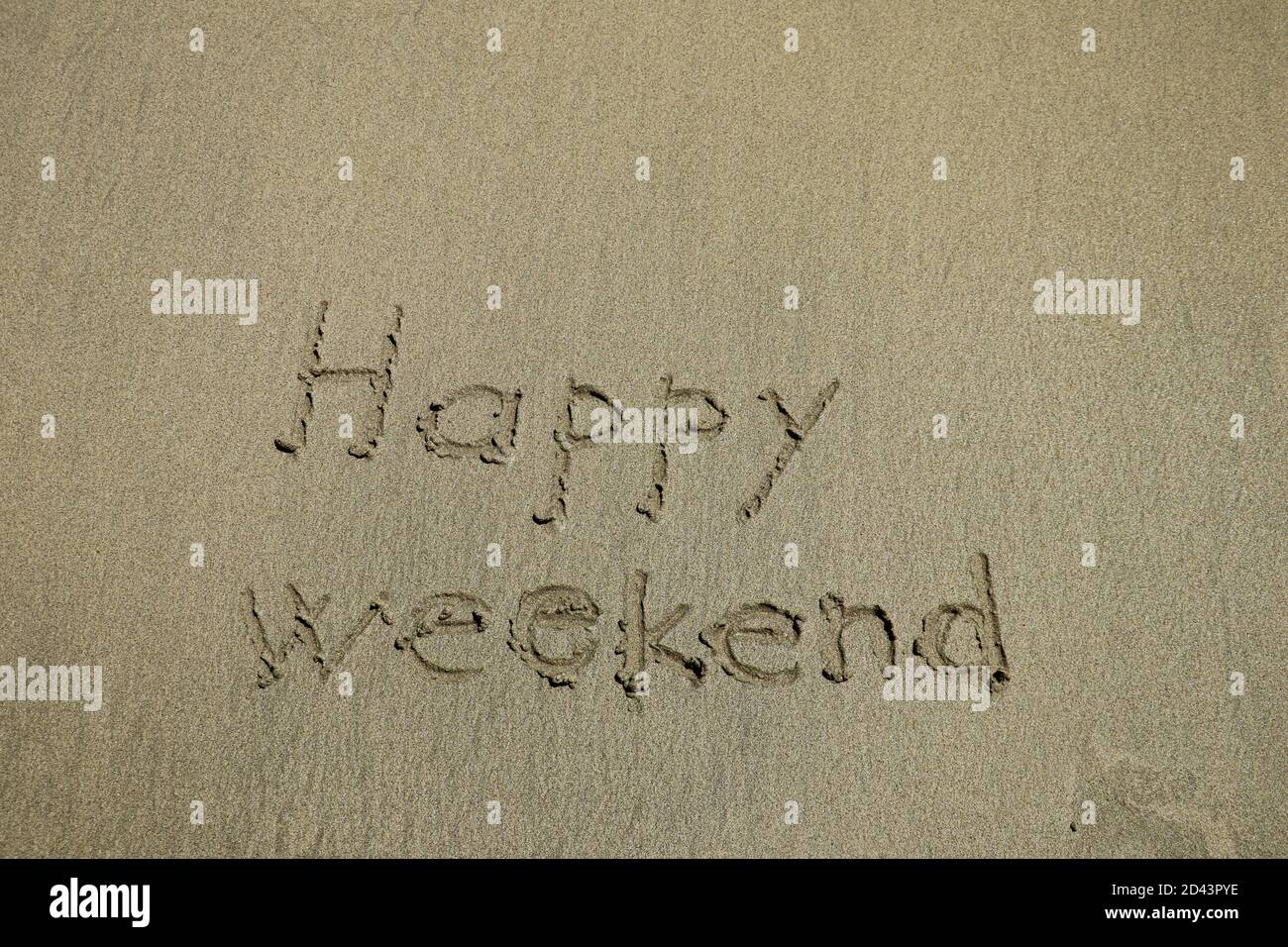 feliz fin de semana escrito en una playa de arena blanca tropical Foto de stock