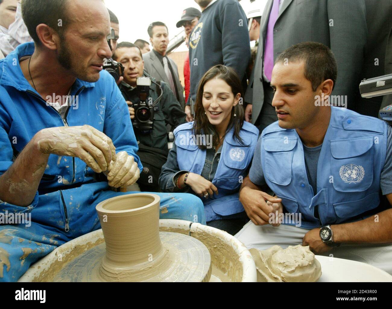 El colombiano Juan Pablo Montoya (R) de Williams BMW habla con un artesano  (L) mientras su esposa Connie mira en la plaza de los artesanos en Bogotá,  6 de agosto de 2003.