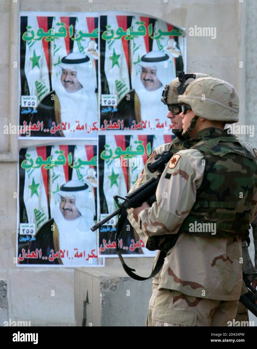 U.S. Army soldiers stand near an election poster after a suicide car bomb attack outside the Australian embassy in Baghdad January 19, 2005. Suicide car bombers attacked the Australian embassy and a police headquarters in Baghdad on Wednesday, killing at least seven people in the latest deadly guerrilla strikes before Iraq's January 30 elections. REUTERS/Ali Jasim RCS/acm Foto de stock