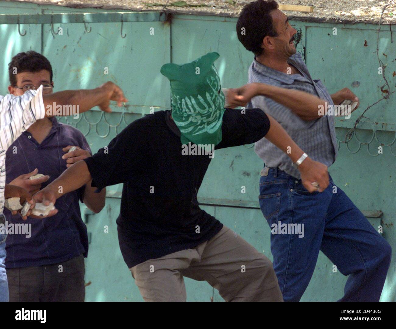 Los palestinos lanzaron piedras contra soldados israelíes durante enfrentamientos en la ciudad de Hebrón, en la Ribera Occidental, el 13 de agosto de 2001. Los palestinos de la Franja de Gaza y la Ribera Occidental cerraron tiendas y oficinas el lunes en protesta contra la toma por parte de Israel de la emblemática sede palestina en Jerusalén. NH/RKR Foto de stock