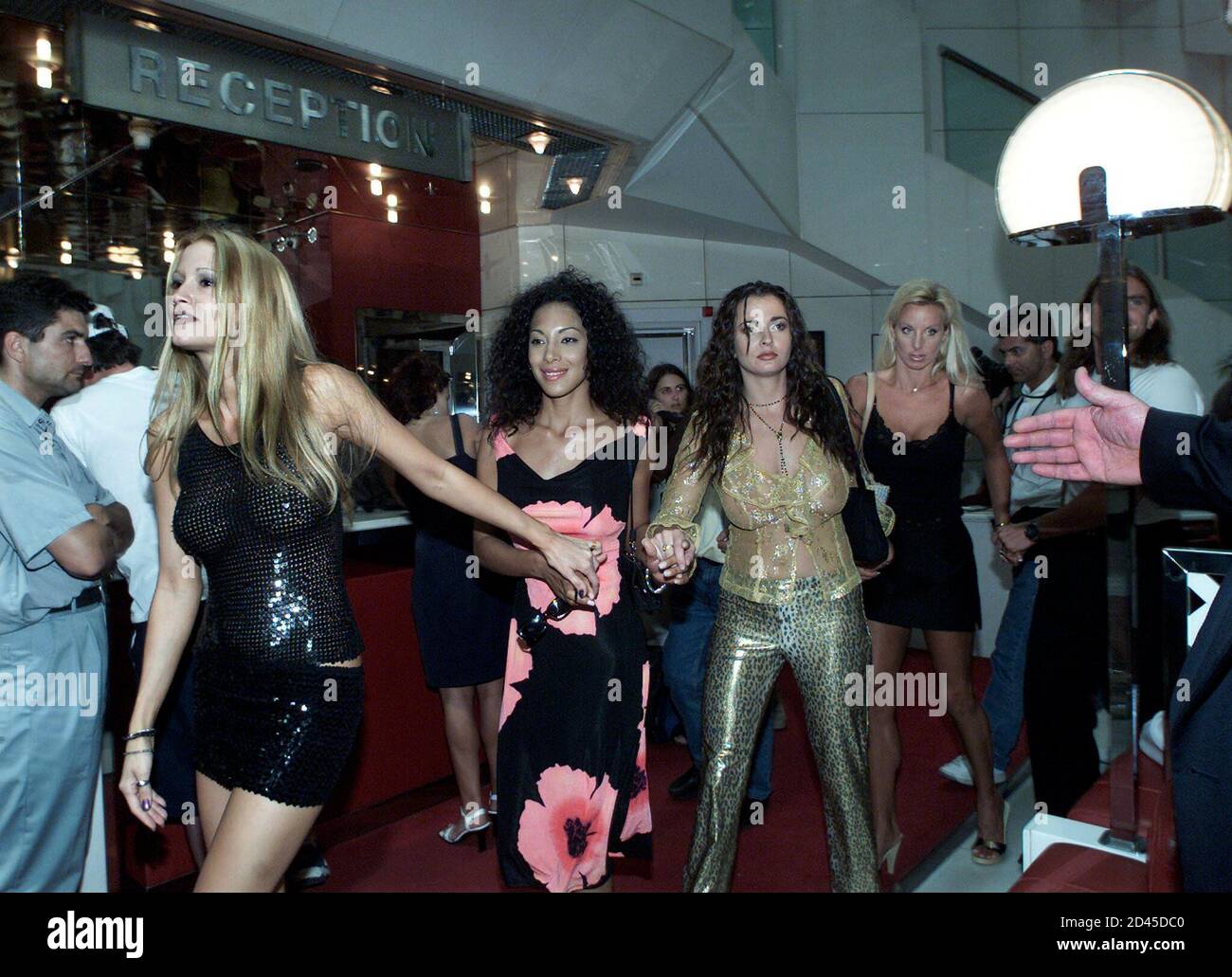 Las actrices porno tienen las manos mientras caminan por el vestíbulo para  salir de un hotel en Cannes, 15 de mayo de 2001. Una reunión de prensa para  actrices y actores de