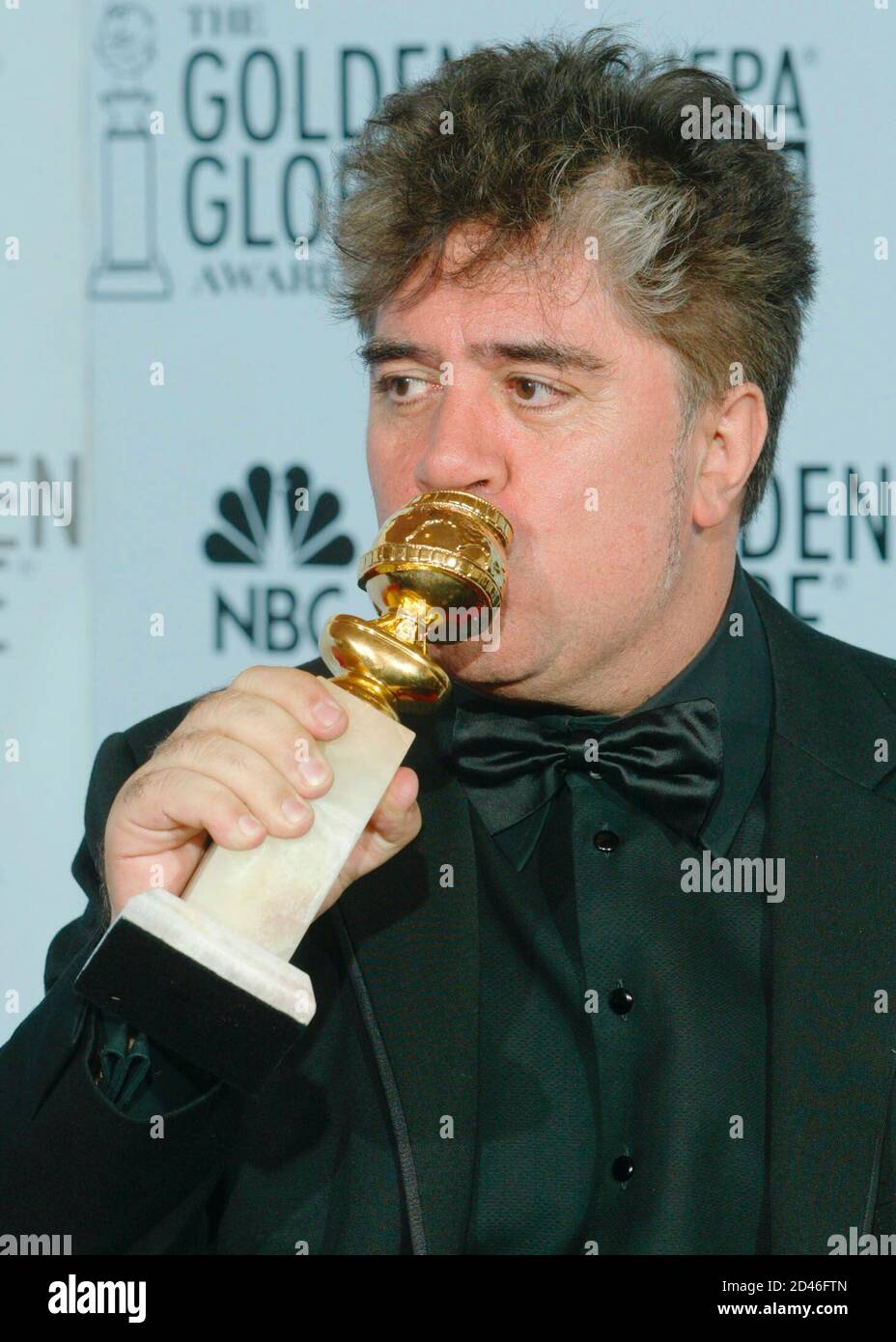 El director español Pedro Almodovar besa su premio Globo de Oro en la ceremonia en Beverly Hills, California el 19 de enero de 2003. Almodovar ganó la mejor película de galga extranjera por su película 'Hable con ella'. REUTERS/Andy Clark BS/ME Foto de stock