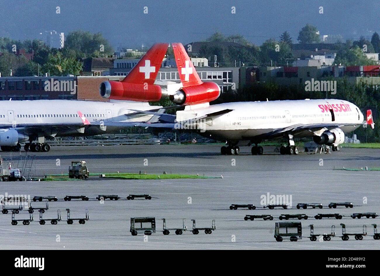 Los aviones Swissair no utilizados y los carros de equipaje se encuentran  en el asfalto del aeropuerto internacional de Zurich el 11 de octubre de  2001. Los líderes sindicales dijeron el jueves