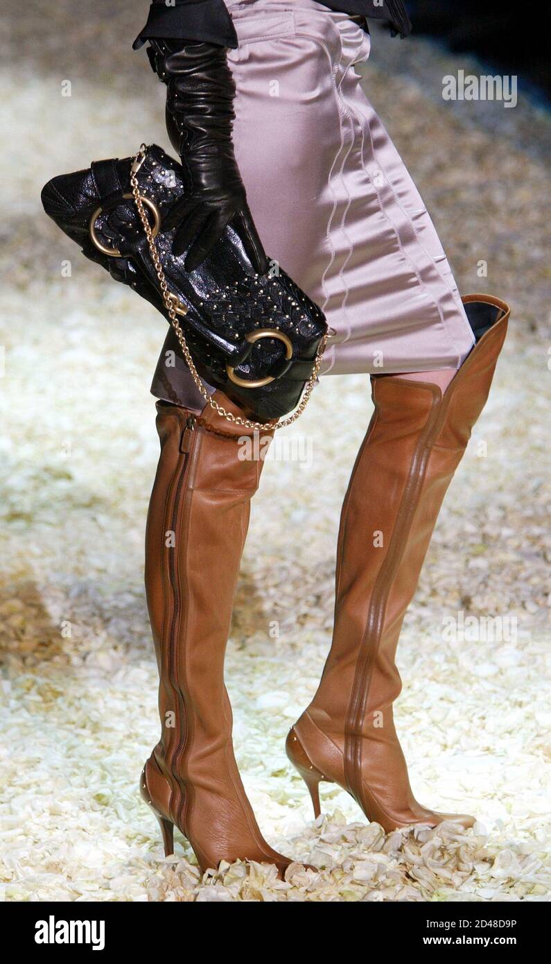 Un modelo muestra unas botas de cuero marrón con bolsa de mano de cuero  como parte de la colección otoño/invierno 2003/2004 de Gucci para mujer el  1 de marzo de 2003, en
