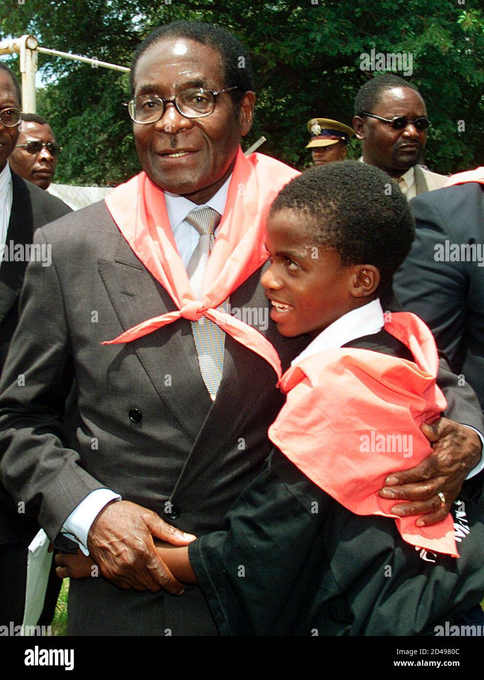 El presidente de Zimbabwe, Robert Mugabe, abraza a un joven miembro del Movimiento 21 de febrero en sus celebraciones oficiales celebradas por la juventud de Zimbabwe y el Movimiento 21 de febrero en la ciudad turística de Victoria Falls el 24 de febrero de 2001. Mugabe, que tenía 77 años el miércoles, prometió seguir adelante con su controvertido programa de reforma agraria, diciendo que era la única solución a la crisis económica del país. La bufanda roja es un símbolo del Movimiento del 21 de febrero. HB/AA Foto de stock