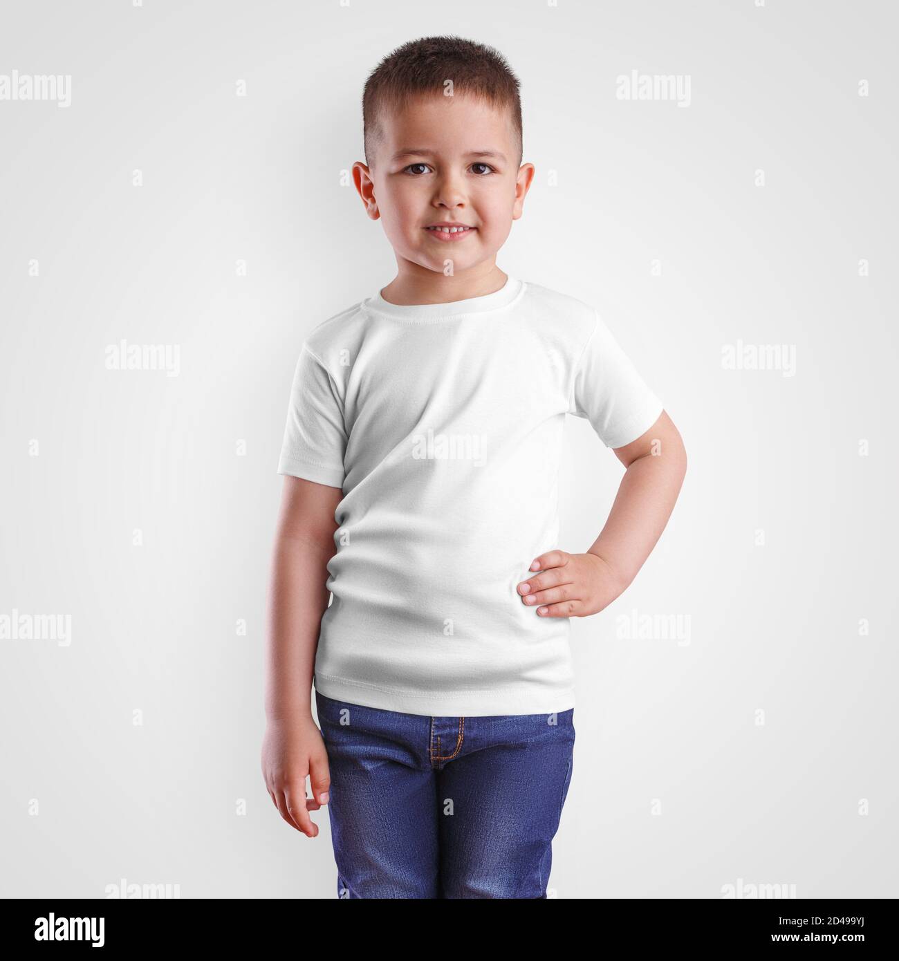 Plantilla de ropa de moda para niño en camiseta blanca y jeans azules con  la mano en el cinturón, ropa infantil en blanco para la presentación del  diseño. Ropa de mascup para