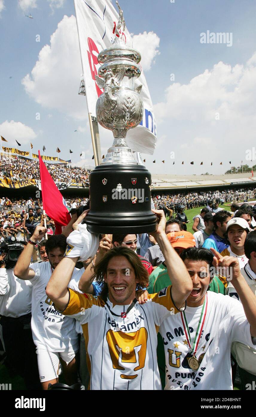 Argentine striker Bruno Marioni of Pumas holds up the Mexican league  championship trophy after winning the final against Chivas at the  University stadium in Mexico City, June 13, 2004. Pumas won the