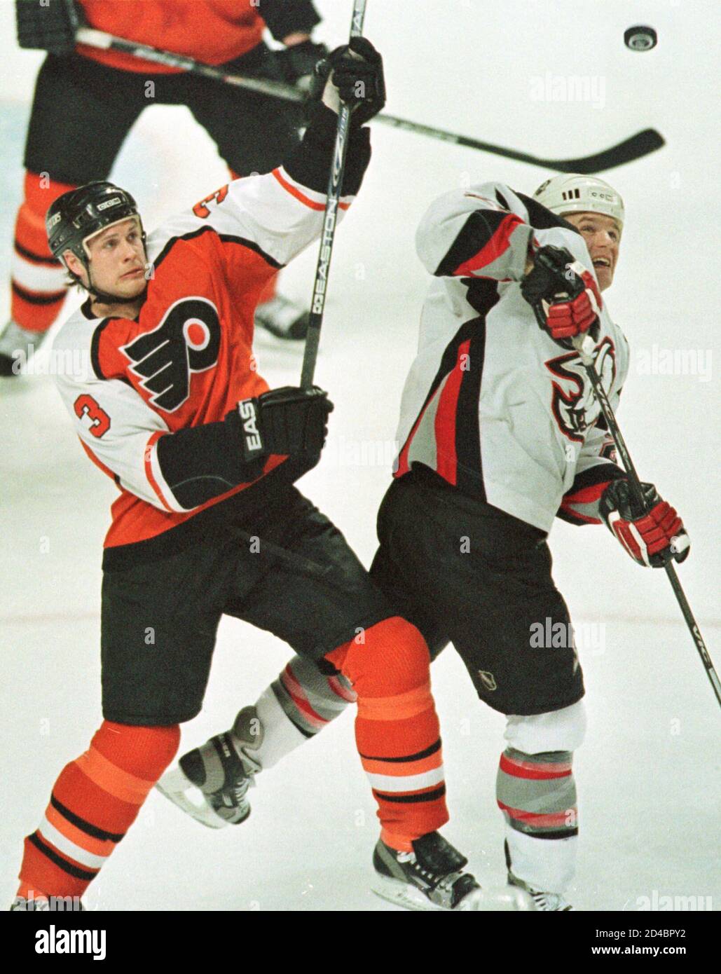 Buffalo Sabre winger Vaclav Varada (R) mira el puck volador con el defensor  del Flyer de Filadelfia Dan McGillis (3) en el primer período el 8 de abril  de 2001 en el