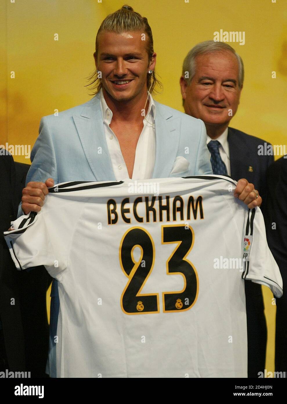La nueva firma del Real Madrid David Beckham (L) lleva su nueva camiseta  del equipo mientras es observado por un miembro sin igual de la junta en  Madrid el 2 de julio