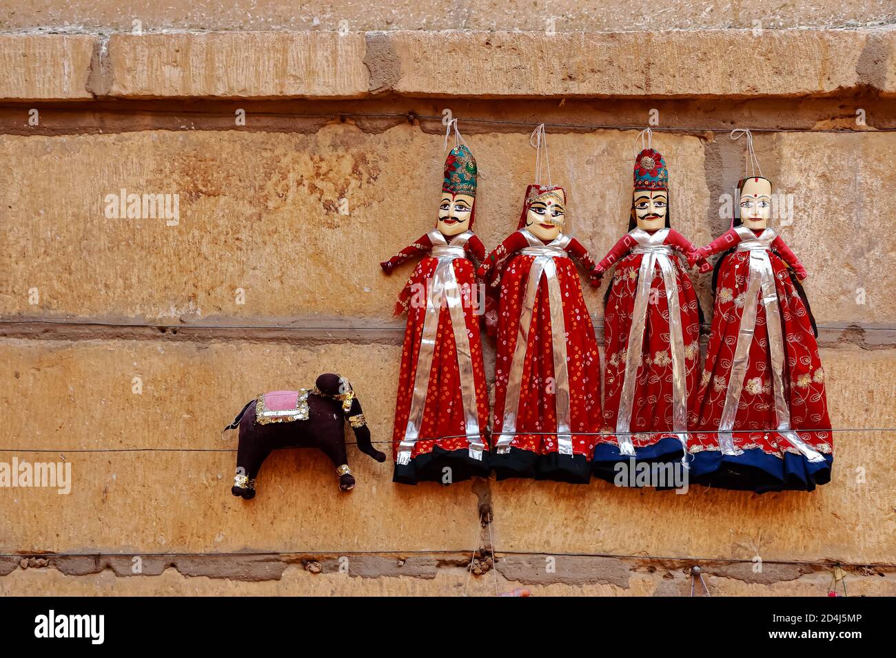 Marionetas coloridas con forma humana con ropa de colores colgando contra el Muro en Rajasthan India el 21 de febrero de 2018 Foto de stock