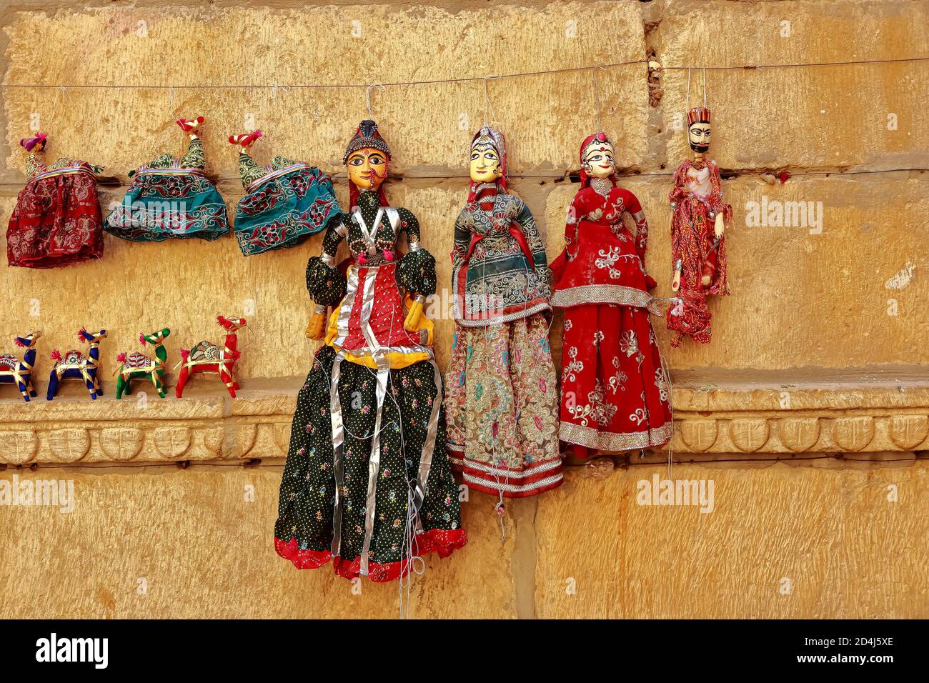 Marionetas coloridas con forma humana con ropa de colores colgando contra el Muro en Rajasthan India el 21 de febrero de 2018 Foto de stock