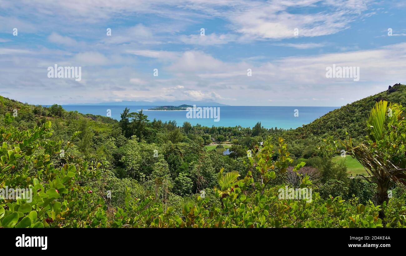 Vista panorámica sobre el norte de la isla Praslin, Seychelles con selva tropical y las dos pequeñas islas primo y Cousine, así como Mahe. Foto de stock