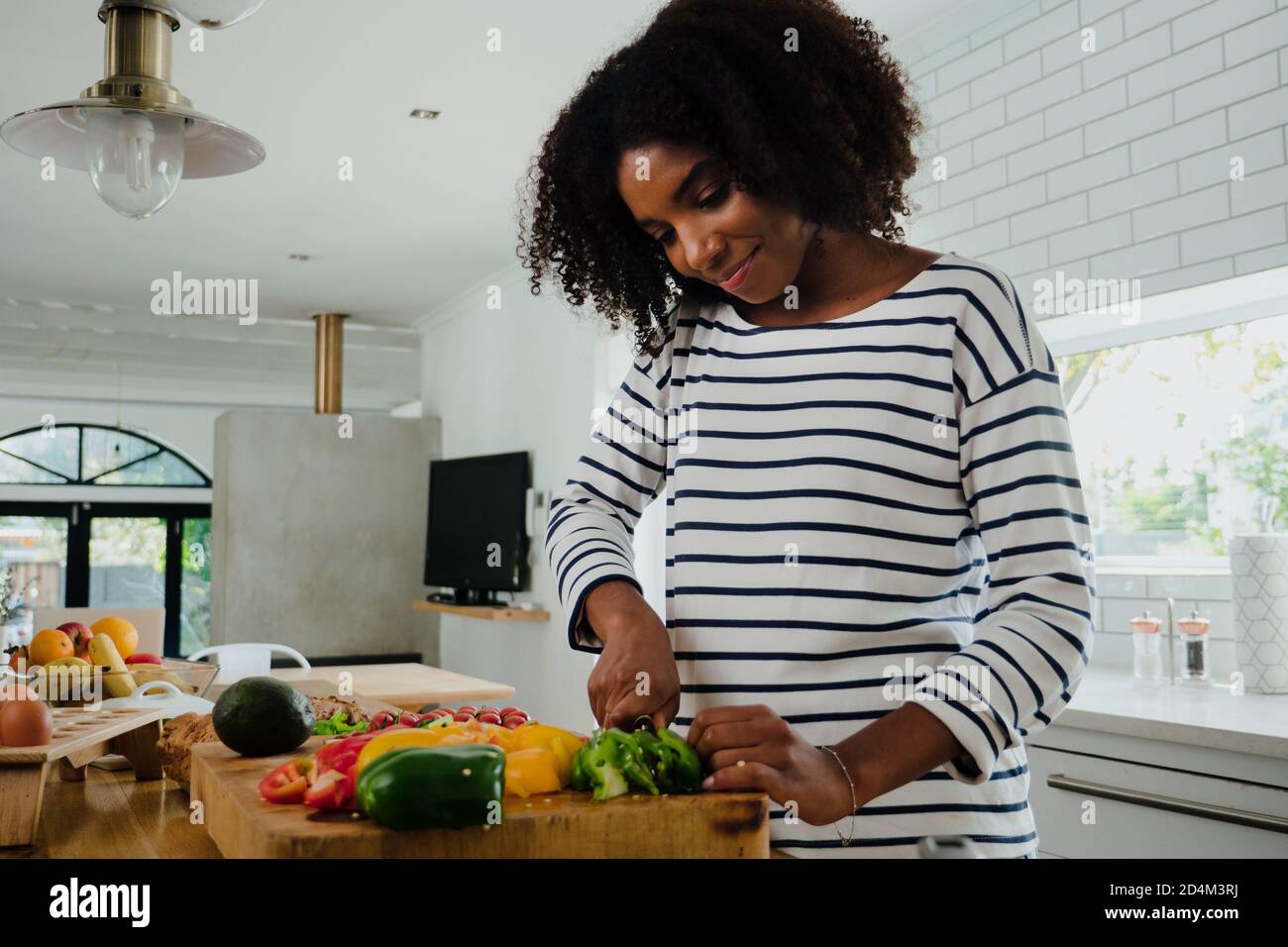 mujer mixta haciendo comida en la cocina Fotografía de stock - Alamy