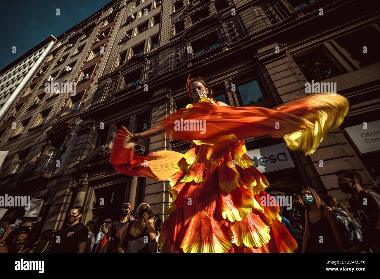 Barcelona, España. de octubre de Un actor baila sobre pilotes miembros de la marcha nocturna de Barcelona detrás de su bandera a través de la protestando por su