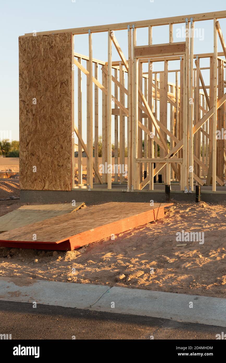 Una nueva casa que muestra el marco de madera antes de la pared y el revestimiento. Se encuentra en un lote de tierra. Foto de stock