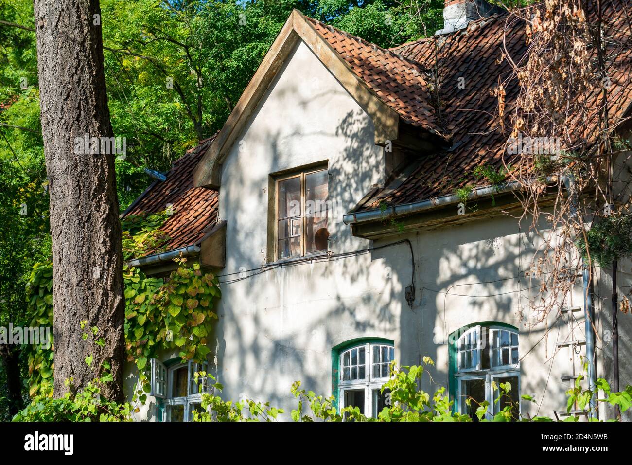 casa del siglo xix con techo de baldosas. Detalles de la fachada frontal, hermosa casa antigua en el bosque. Foto de stock
