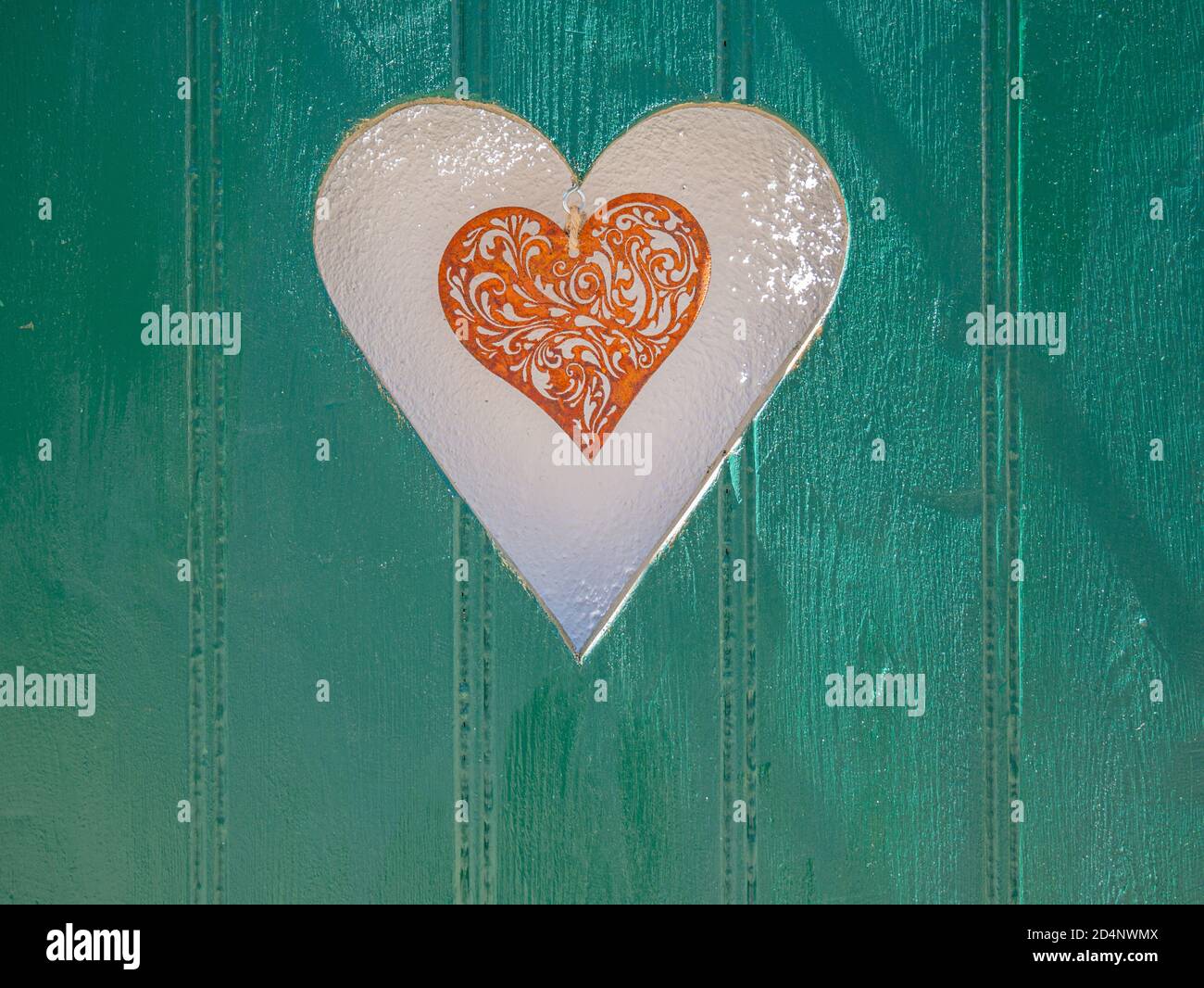 Tablas de madera verde con corazón colgante en corte de corazón Foto de stock