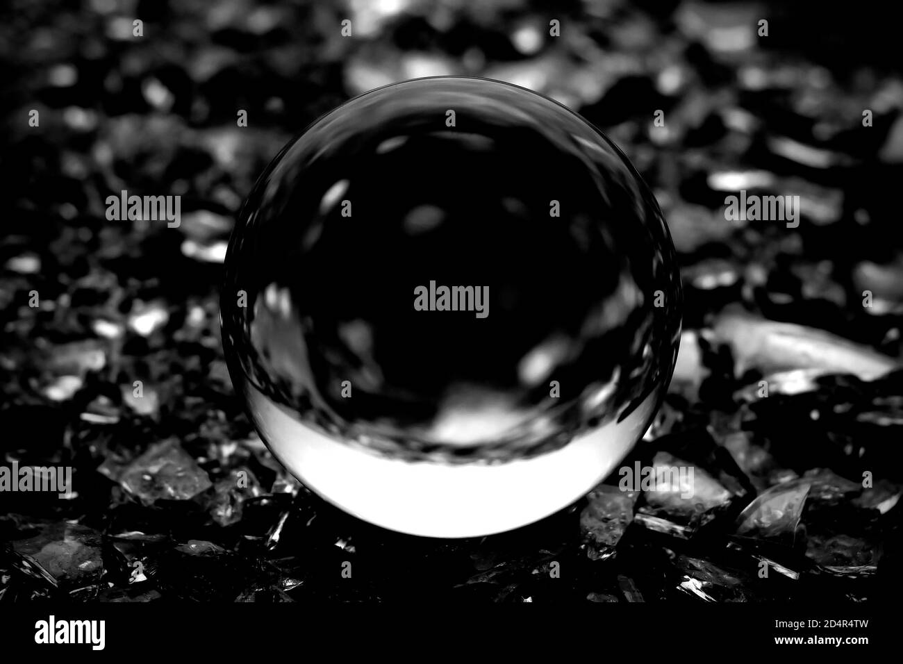 Una imagen borrosa de una bola de cristal transparente. Imagen en blanco y negro de una pelota de lente en borrosidad abstracta. Foto de stock
