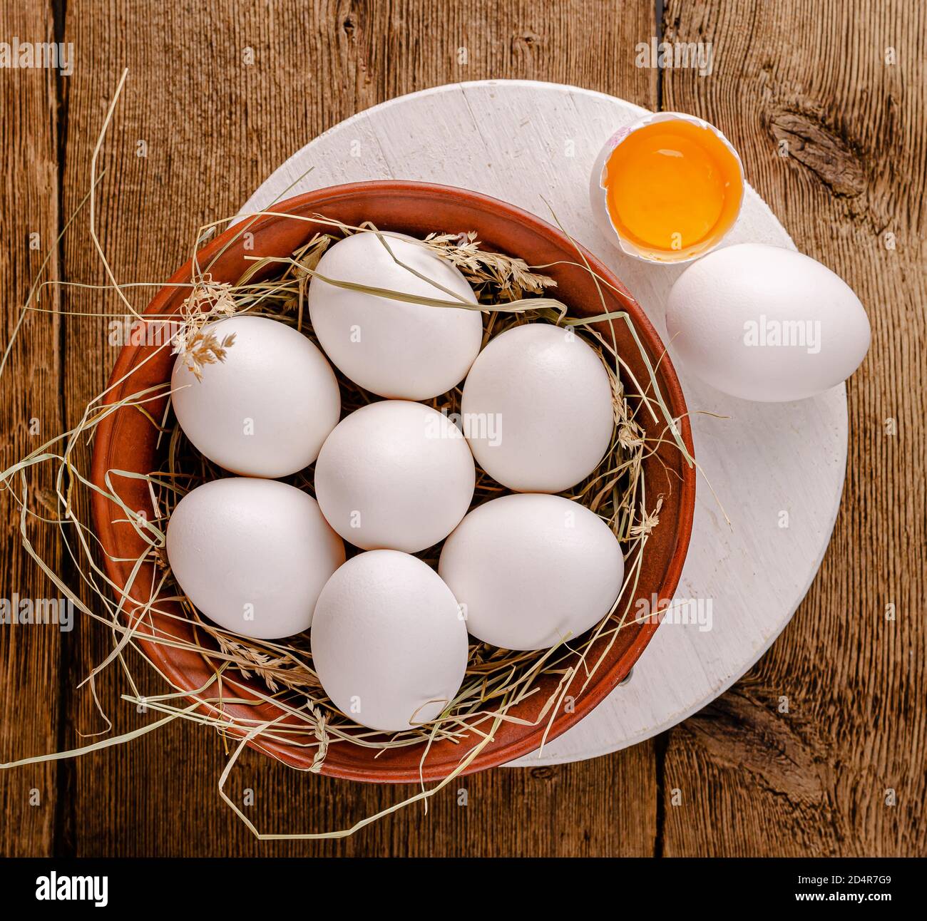 Huevos de pollo blancos en un Bol sobre una mesa de madera. Vista superior. Foto de stock