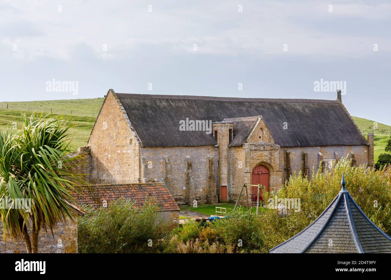 El granero grande del diezmo en las ruinas de la Abadía de Abbotsbury, un antiguo monasterio benedictino en Abbotsbury, Devon, al sureste de Inglaterra, visto desde Abbey House Foto de stock