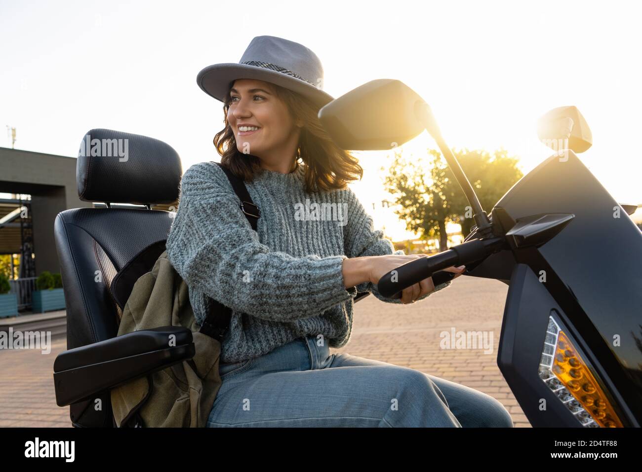 Mujer turística montando un scooter eléctrico de movilidad de cuatro ruedas en una calle de la ciudad. Foto de stock