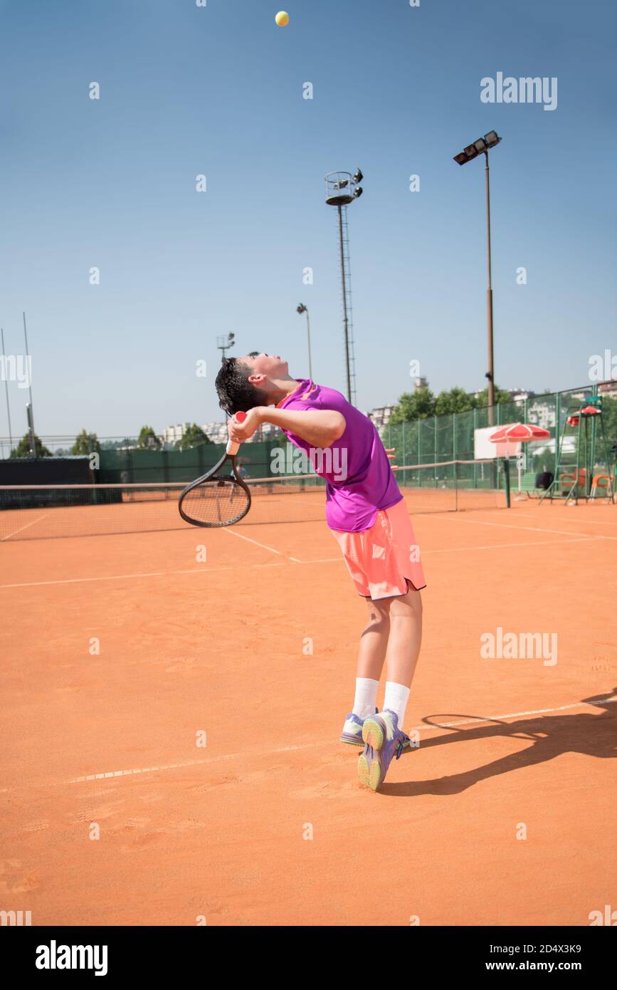 Joven jugador de tenis sirviendo la pelota Foto de stock