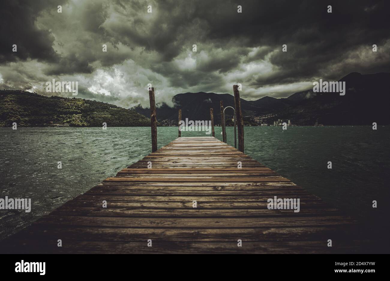 Región lombarda italiana Lago Iseo tiempo tormentoso y el muelle de madera. También conocido como Sebino. Italia, Europa. Foto de stock