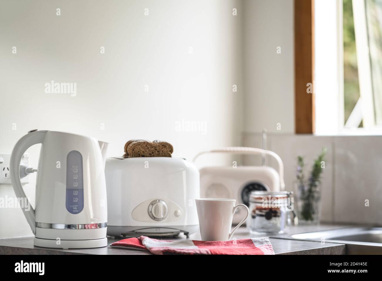Mesa de desayuno con electrodomésticos blancos, Hervidor eléctrico tostador,  taza y radio vintage Fotografía de stock - Alamy
