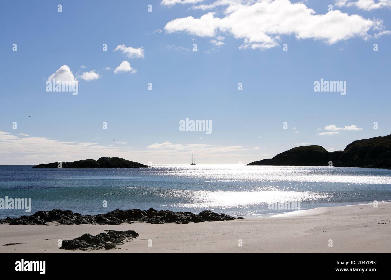 Yate pasando por la playa Scoor, una playa de arena aislada, en el Ross de Mull, Isla de Mull, Escocia Reino Unido Foto de stock