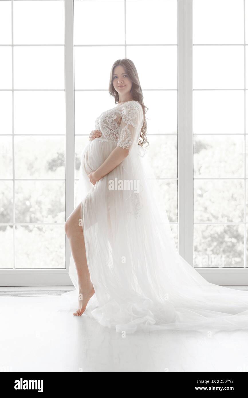 hermosa embarazada joven con vestido largo blanco Fotografía de stock Alamy