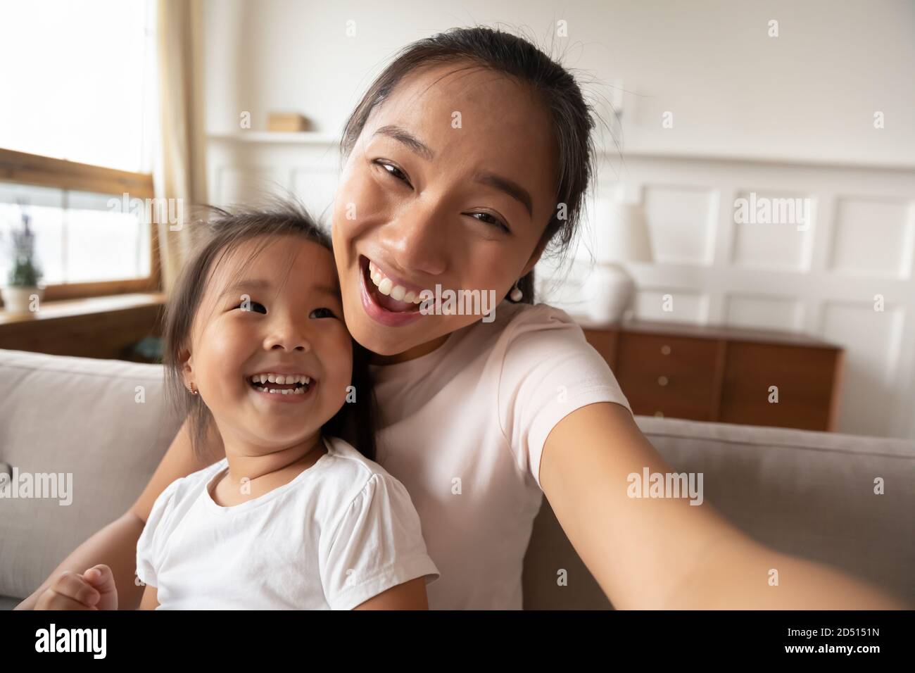 De cerca sonriente madre asiática y niña tomando selfie Foto de stock