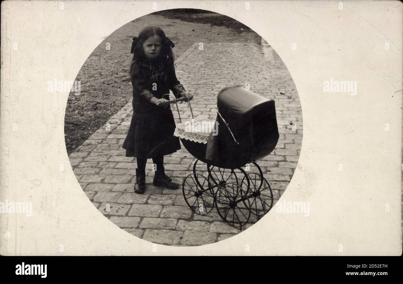 Junges Mädchen mit ihrem Puppenwagen, Standretrato | uso en todo el mundo Foto de stock