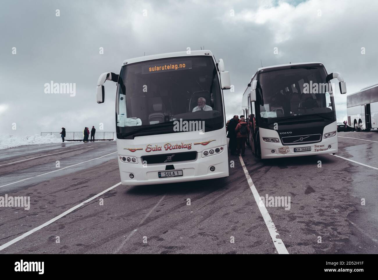 Editorial 09.07.2019 Dalsnibba Noruega, autobuses y turistas en el estacionamiento en la parte superior de Dalsnibba con nieve en un día brillante Foto de stock