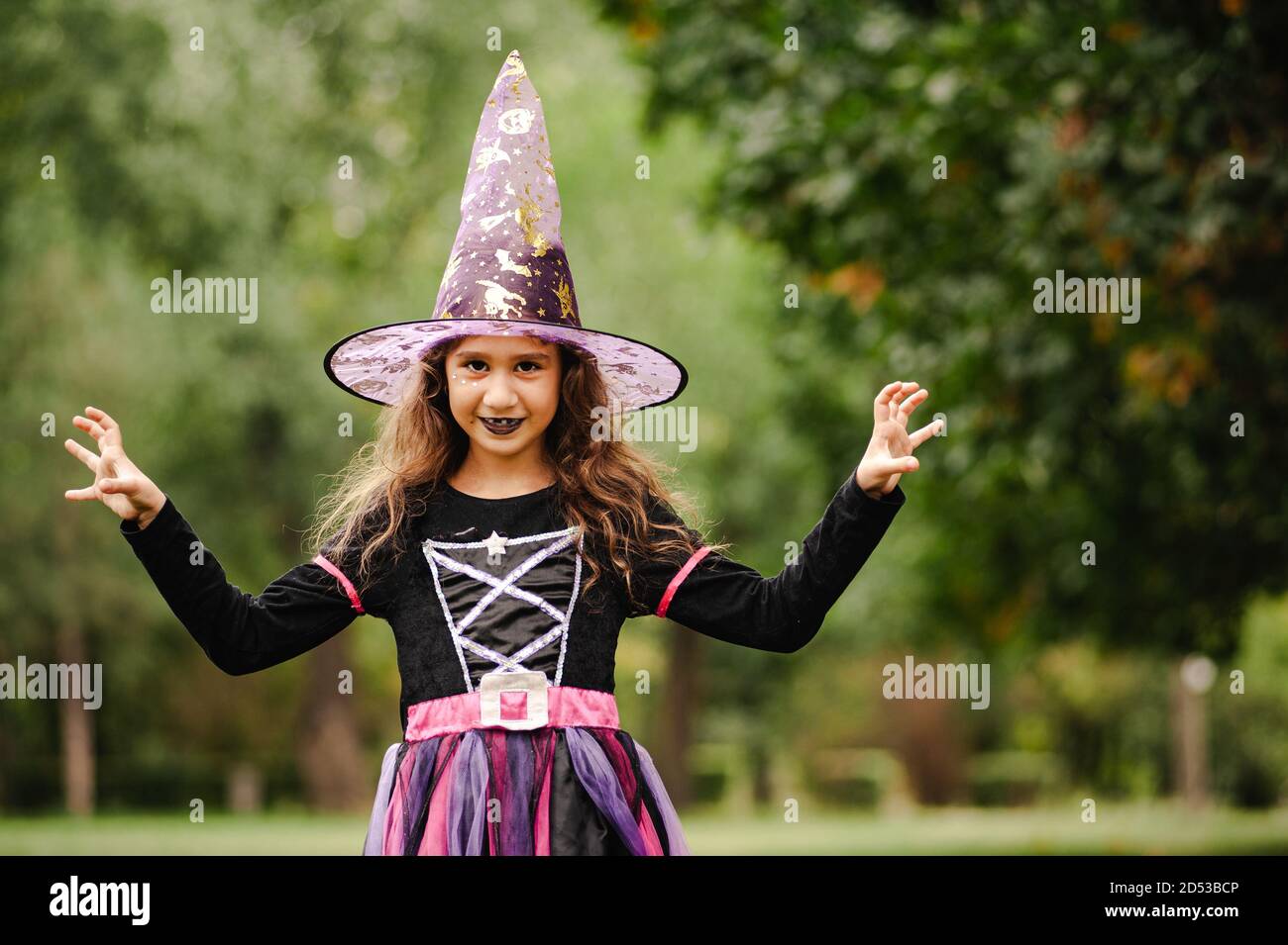 Chica con pelo rizado en un traje de bruja para Halloween Fotografía de  stock - Alamy