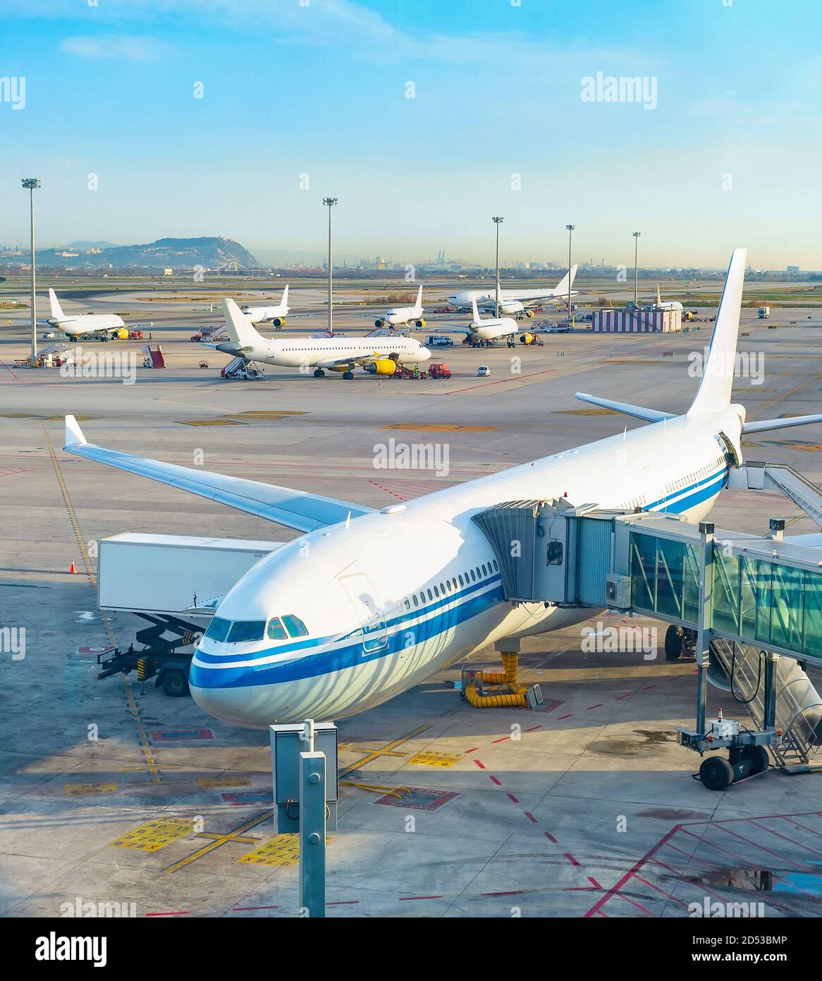 Pasillo telescópico de vidrio por avión, pista de aterrizaje del aeropuerto, aviones en el fondo en el campo de aviación. Barcelona, España Foto de stock