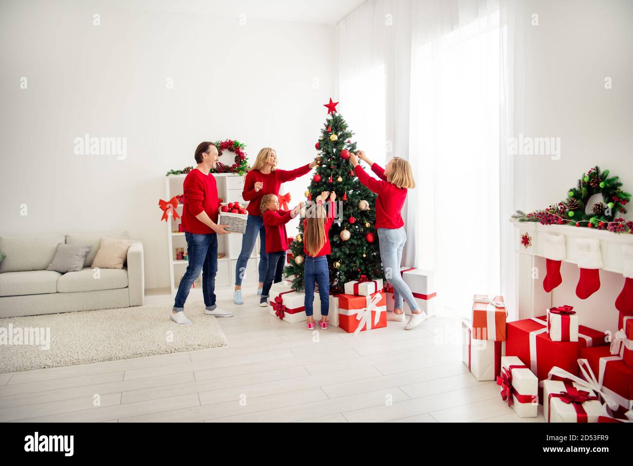 Foto de familia grande cinco personas reuniéndose con tres pequeños los  niños adornan navidad árbol papá ayudar a traer cesta bolas guirnalda use  pantalones vaqueros de jumper rojo en casa Fotografía de