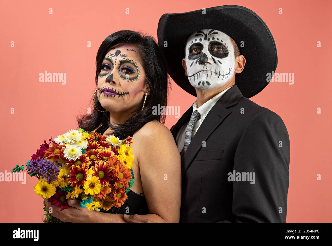 Una pareja disfrazada de catrin y catrina mientras ella es la celebración  de un ramo de flores posando con una llanura antecedentes Fotografía de  stock - Alamy